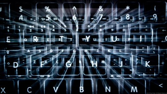 A stylized photo of a backlit keyboard with multiple overlapping ghostly photos of itself overlayed.