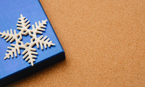 Blue box with Christmas present and white snowflake.